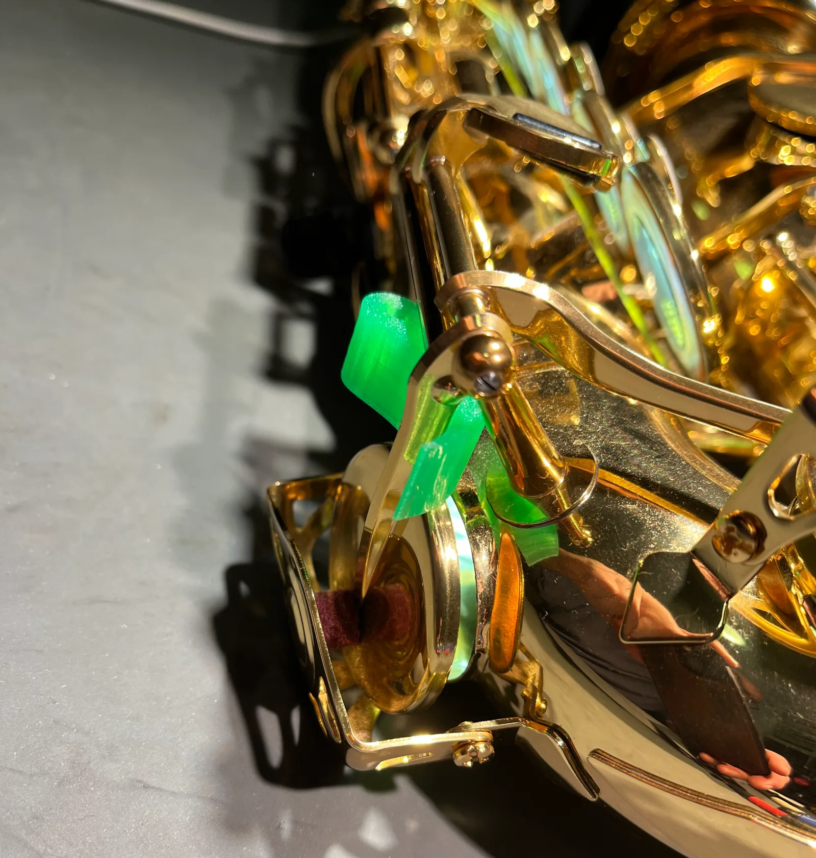 Green wedge placed in the mechanism by the low keys of a saxophone, holding the key slightly open